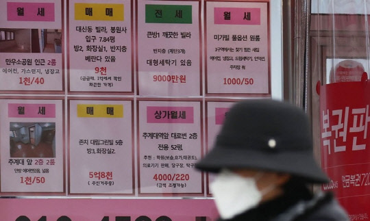 한 시민이 부동산 공인중개업소 앞을 지나가고 있다. <연합뉴스>